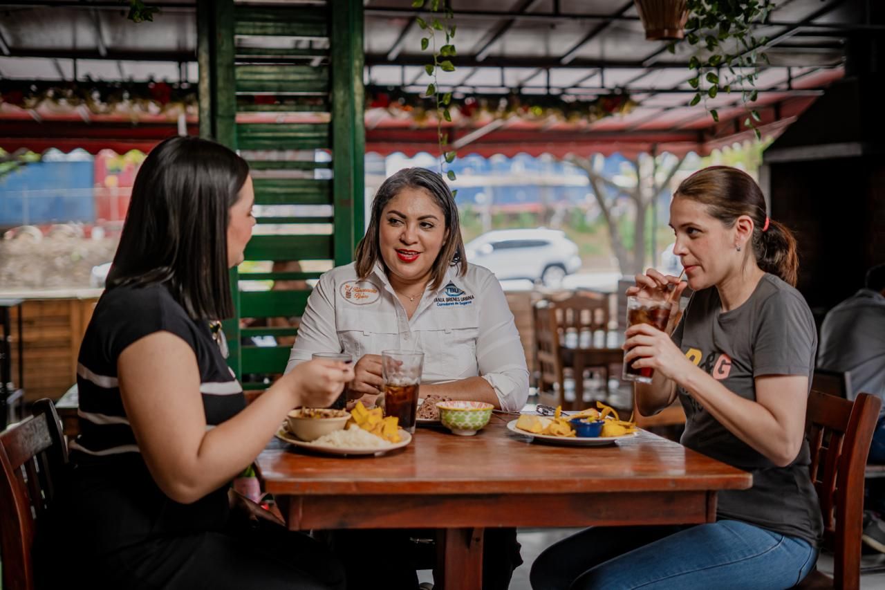 Tres amigas conversando y comiendo en una mesa del restaurante