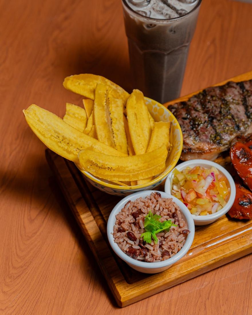 Churrasco en tabla con tajadas, gallo pinto, pico de gallo y chorizo