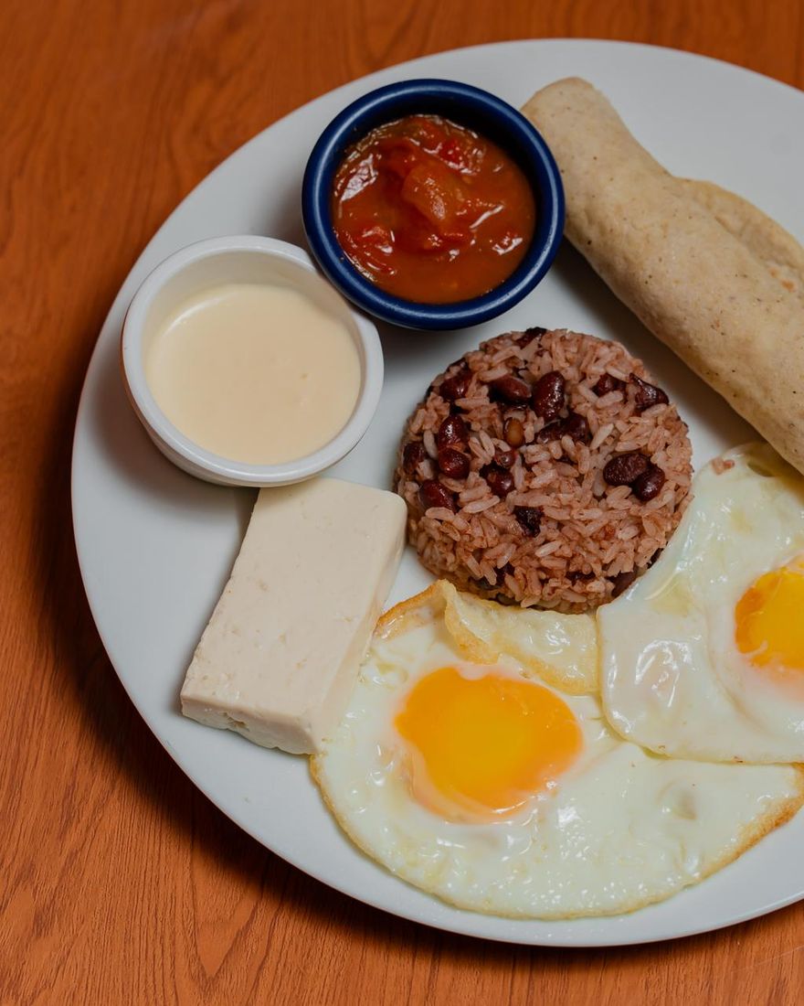 Desayuno típico con gallo pinto, huevos fritos, queso, crema, chile y tortilla